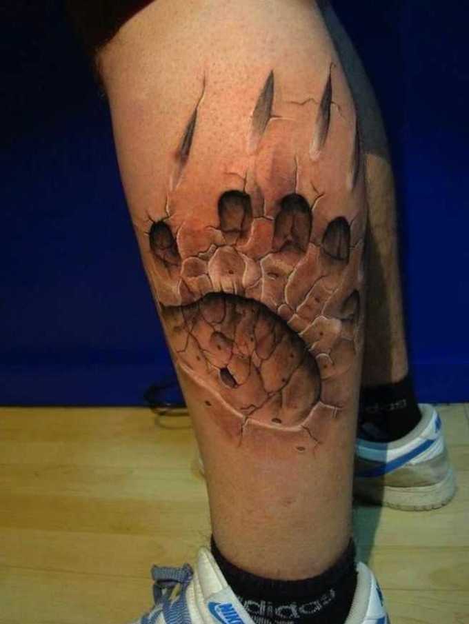 Tattoo in the form of a bear's paw print on the shin
