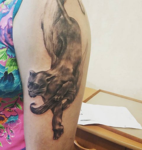 Female tattoo of a panther on her shoulder